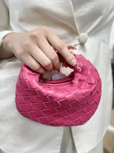 Detailed view of the pink woven leather handbag showing exquisite craftsmanship and texture.