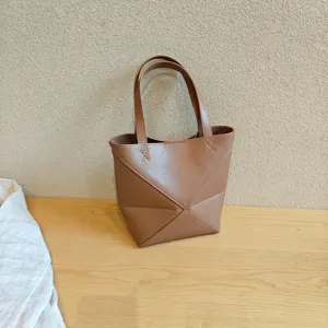 Vue détaillée du sac cabas géométrique en cuir marron montrant de fines coutures et texture.