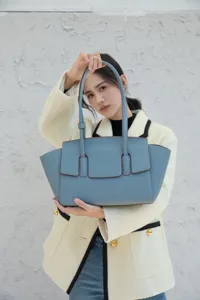 Elegant blue leather tote bag for women, stylish shoulder bag with unique winged design.