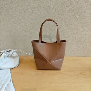 Détail de sac cabas en cuir géométrique pliable, élégant sac porté épaule marron grande capacité.