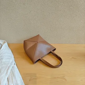 Vue détaillée du sac cabas géométrique en cuir marron avec un design de pliage unique.