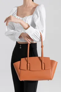 Detailed view of the elegant caramel leather tote bag with stylish vertical handles.