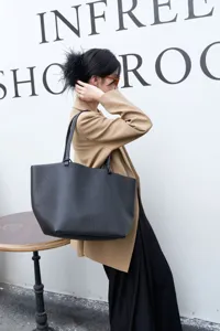 Detail view of a black genuine leather tote bag featuring large capacity and minimalist design.