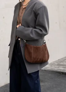 Close-up detail shot of the brown suede hobo shoulder bag, showcasing textured leather and hardware.
