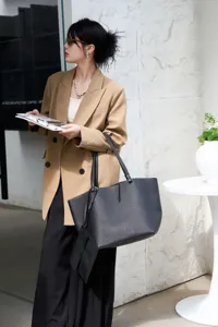 Classic black leather tote bag for women, large capacity minimalist commuter shoulder handbag.