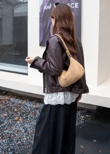 Detail view of brown suede shoulder bag, stylish croissant hobo design for daily autumn wear.