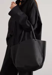 Detail shot of a minimalist black leather tote bag, perfect for daily commuting and large capacity.