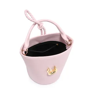 Detailed close-up showing the interior lining and unique gold ring clasp of the pink bucket bag.