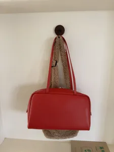 Minimalist red leather bowling bag for women, stylish shoulder handbag for daily commute.