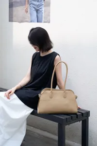 Detailed view of the chic beige leather tote bag with long handles, stylish everyday carry.