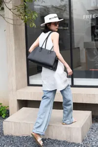 Black leather East-West tote bag for women, stylish horizontal shoulder bag with dual handles.