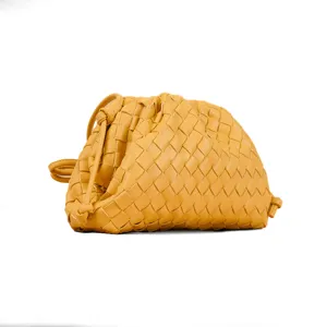 Detailed view of yellow woven leather clutch bag, stylish mini pouch shoulder bag for women.