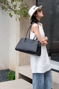 Black litchi grain leather shoulder bag with long handles, chic everyday tote design.