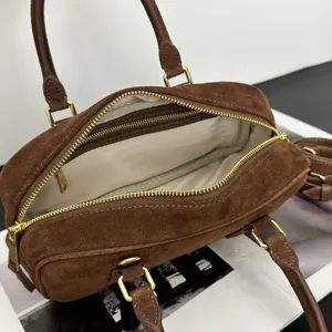 Braune Wildleder Bowlingtasche Detail, luxuriöse Kissentasche mit goldener Hardware.