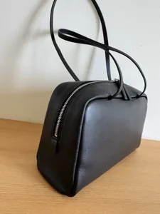 Minimalist black leather shoulder bag detail, elegant everyday commuter handbag design