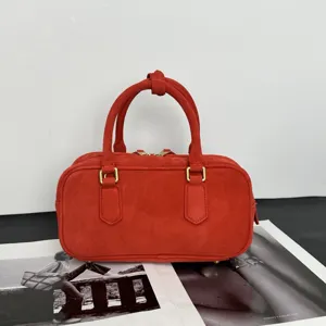 Rote Wildleder Bowling Handtasche Detailansicht mit klassischem Design und goldenen Details.