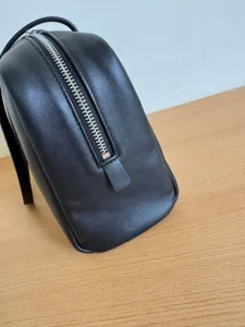 Minimalist black leather shoulder bag for women, elegant daily handbag with silver zipper.