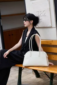 Chic white leather shoulder tote bag with long handles, premium pebble grain finish, elegant.