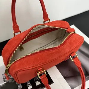 Rote Wildleder Bowling Handtasche mit Henkeln und goldenen Reißverschluss Details für Damen.
