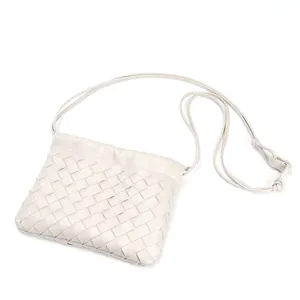 Woven leather crossbody bag detail, chic off-white shoulder purse with elegant knot strap.