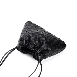 Close-up detail of the black woven leather pouch bag, highlighting intricate intrecciato texture.