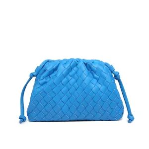 Detailed view of the bright blue woven leather clutch bag with delicate handmade intrecciato design.