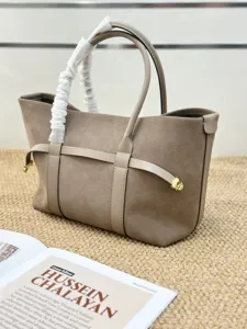 Detalle exquisito del bolso tote de ante en tono topo con elegantes correas de cuero.