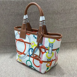 Close up of the colorful canvas tote bag, featuring detailed equestrian print and leather trim.