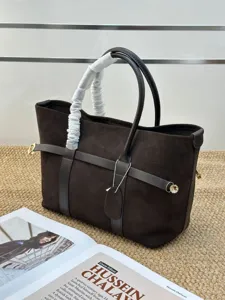 Vista detallada del bolso tote de ante marrón oscuro con textura de piel y detalles metálicos.