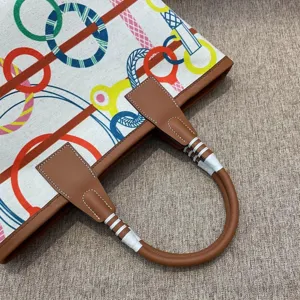 Detailed view of colorful canvas and leather tote bag featuring equestrian steeple graphic print.