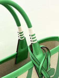 Detailed view of fashionable canvas and leather tote bag with handle wrap design for use.