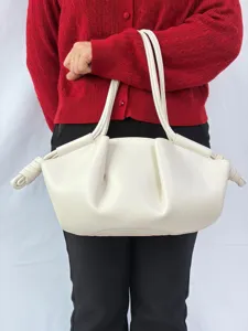 Vue détaillée du sac nuage minimaliste en cuir blanc crème avec de beaux plissés.