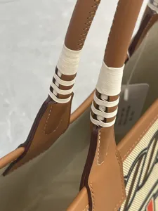 Close-up view of premium brown cowhide leather handles with white thread wrapping detail.