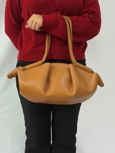 Détail du sac épaule nuage en similicuir marron, avec design plissé et élégantes poignées nouées.