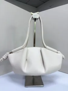 Détail de sac à main nuage plissé blanc, design de sac boulette en cuir synthétique.