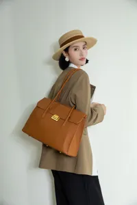 Detailed shot of women's genuine leather commuter shoulder bag with metal lock design.