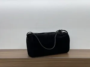 Detailed view of black suede cylindrical shoulder bag showcasing minimalist daily style.