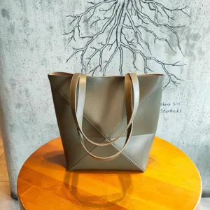Grand sac cabas geometrique en cuir gris, design de pliage elegant pour le travail.