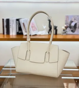 Luxurious beige leather tote bag with classic trapezoid design and top handles for women.