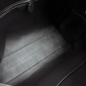 Detailed interior view of luxury genuine leather bowling handbag with spacious black design.