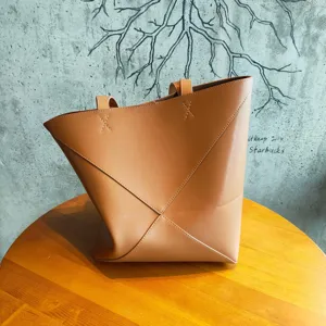 Vue détaillée du sac cabas pliable géométrique en cuir marron, élégant et polyvalent.