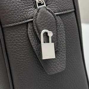 Close-up detail of luxury leather handbag hardware, featuring premium grain cowhide.