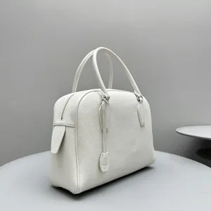 White genuine leather bowling handbag detail showing textured finish and double handles.