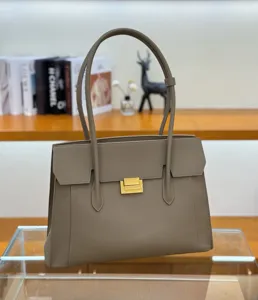 Detailed view of luxury leather tote bag, elegant greyish-brown commuter shoulder bag close-up.