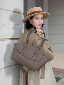 Elegant genuine leather tote bag for women, stylish grey shoulder bag with unique flap design.