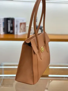 Detail view of brown leather shoulder bag, premium pebble grain texture, elegant side profile.