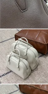 Luxurious genuine leather bowling handbag with top handles, classic minimalist design for women.