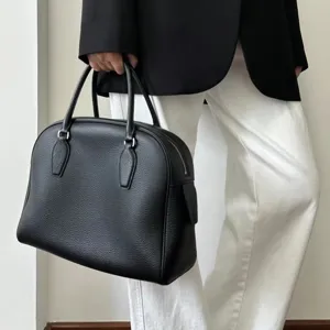 Classic black leather bowling bag, large capacity tote handbag, minimalist design for women.