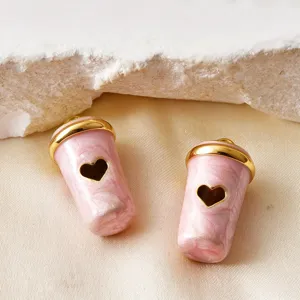 Nahaufnahme von rosa 3D-Kaffeetassen-Anhängern mit Herz-Ausschnitt für DIY-Schmuck