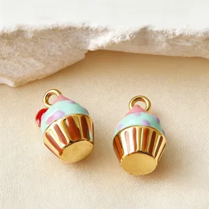Κοντινό πλάνο δύο χαριτωμένων μενταγιόν cupcake από ατσάλι με πολύχρωμο σμάλτο λεπτομέρεια.